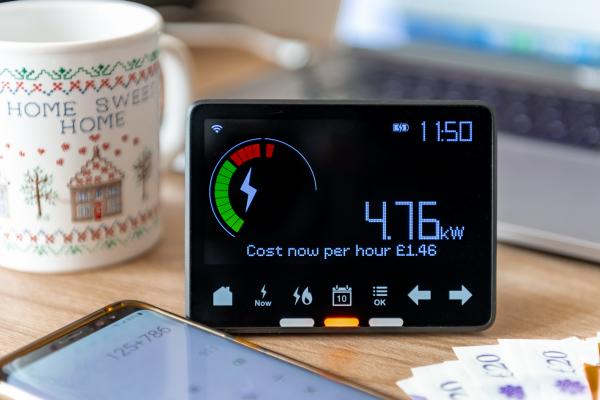 Energy meter, hot drink and a phone on a desk